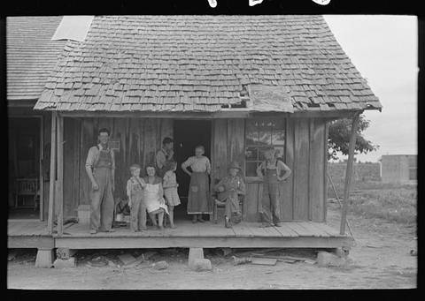 Sharecropper family on front porch of cabin, Southeast Missouri Farms